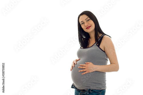 pretty pregnant woman with already big belly posing in studio on white background isolated