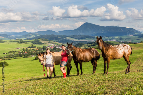 Two girls with a horse on a field in Slovakia