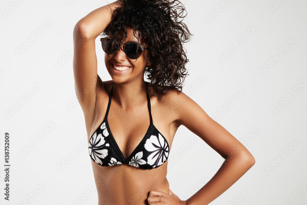 Obraz premium mixed race woman in bikini, curved hair, studio shoot