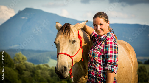 Girl with a blue and red mapped shirt with a horse in Slovakia