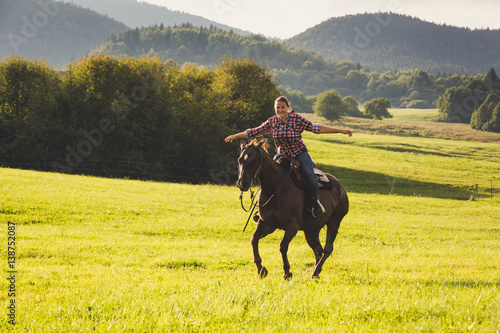 Girl with a blue and red mapped shirt with a horse in Slovakia © oscity
