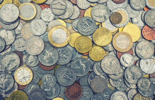 Coins of several currencies - background pattern.