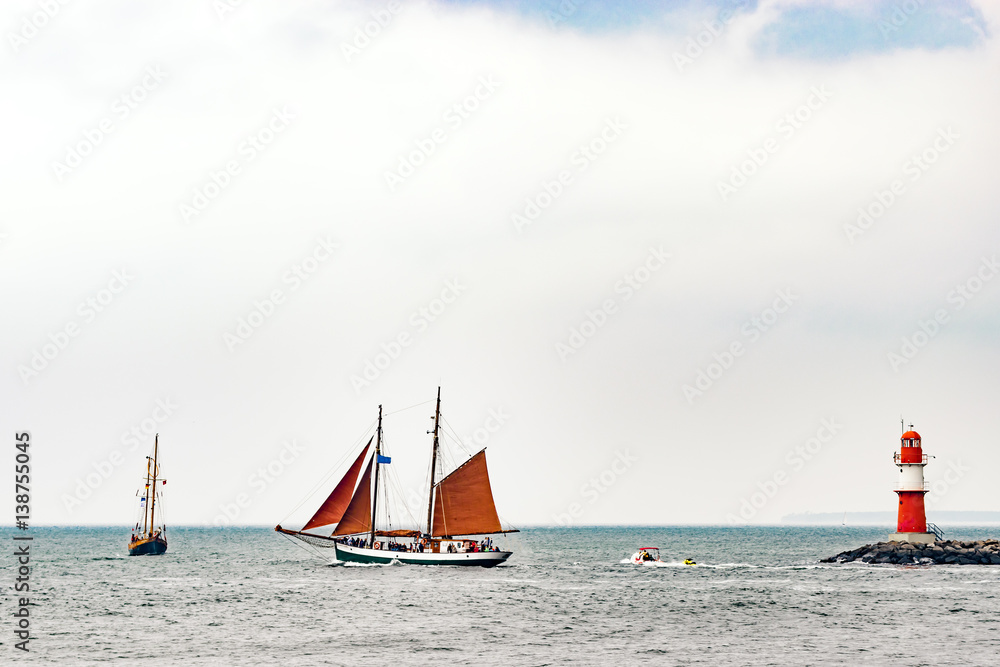 Naklejka premium Sailing ships on the sea. Tall Ship and lighthouse Yachting travel.