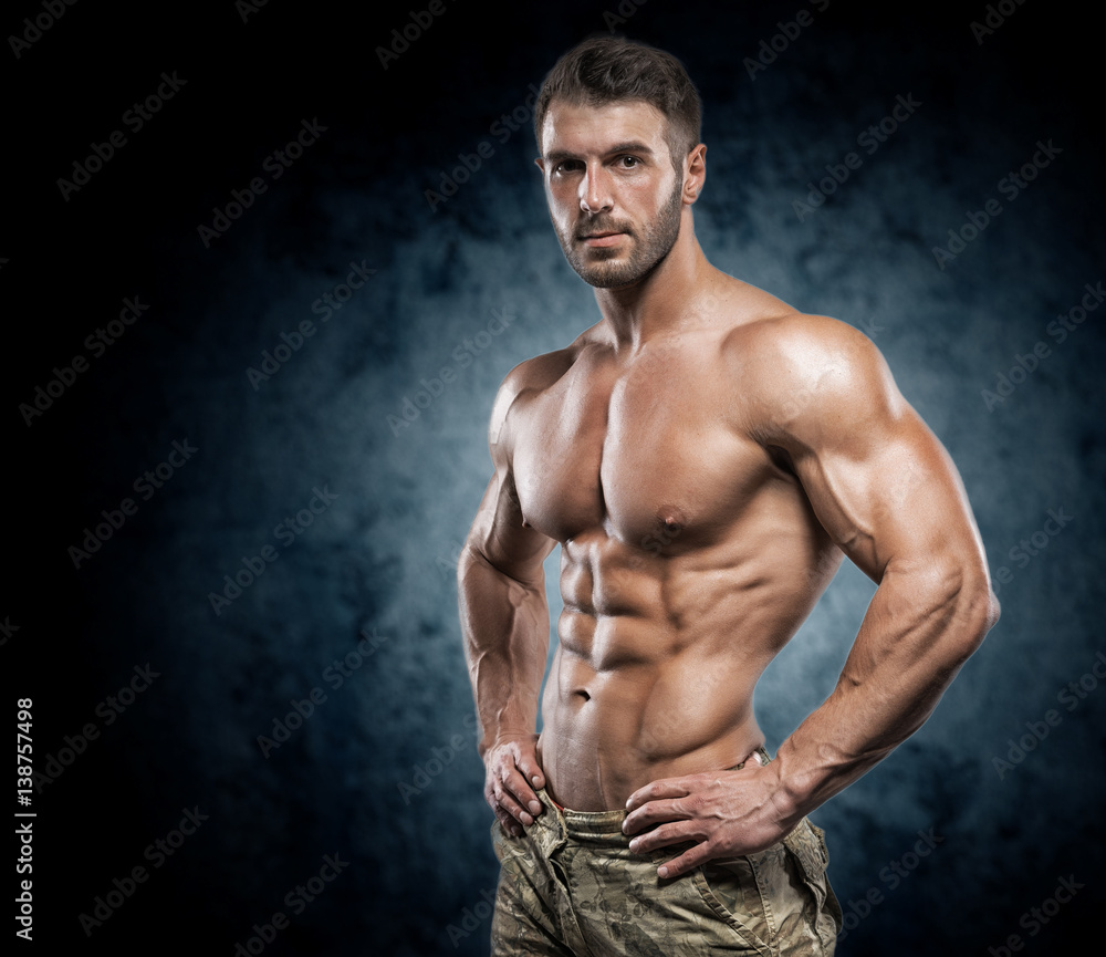 Fototapeta premium Muscular young man in studio on dark background