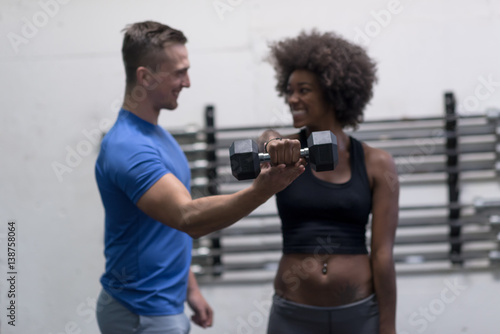 black woman doing bicep curls with fitness trainer © .shock