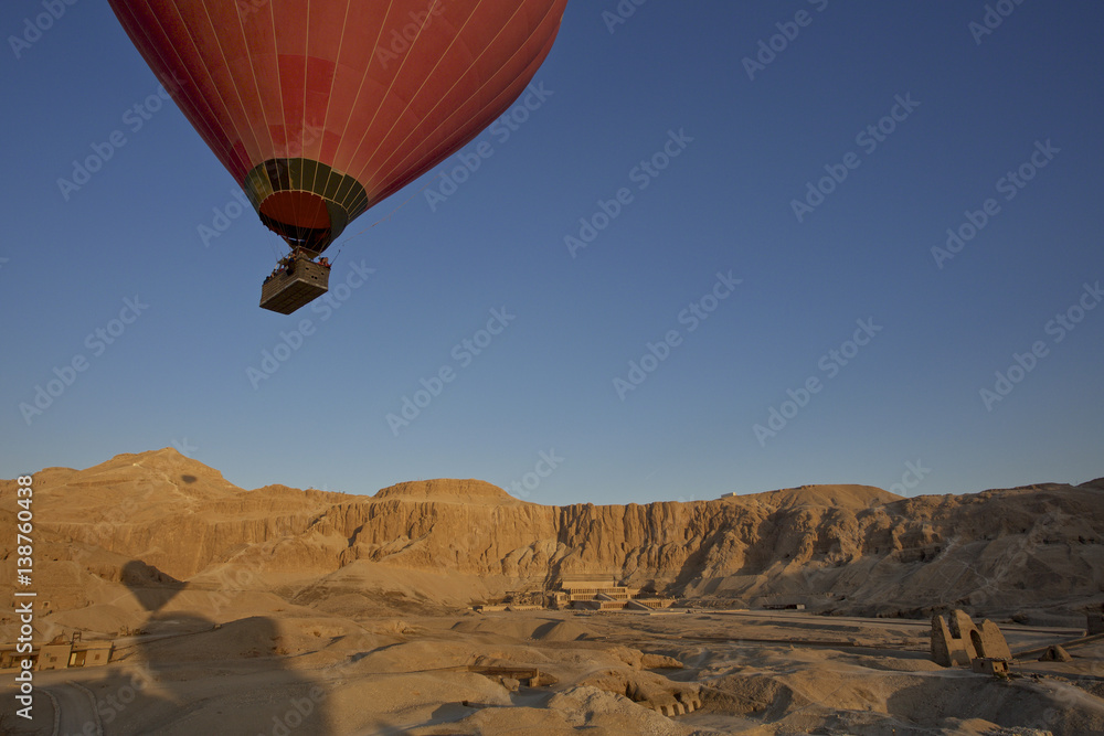 A hot-air balloon in flight over Egypt's Valley Asasif and temple of Queen hatshepsut