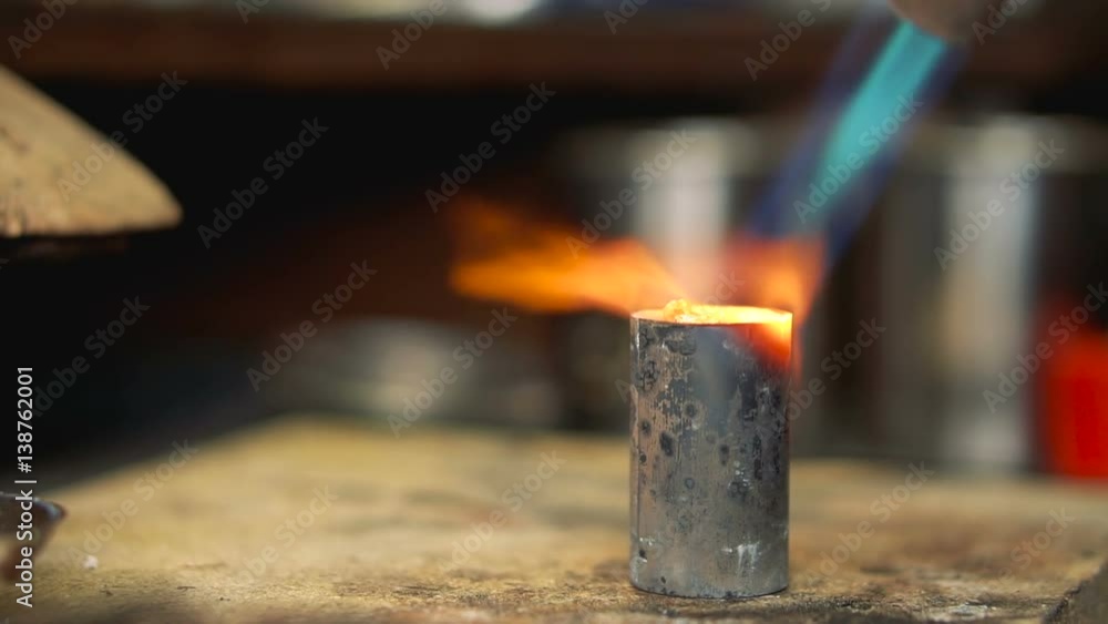 Gas flame flow softens the metal on a wooden table close up Gas flame flow softens the metal on a wooden table close up