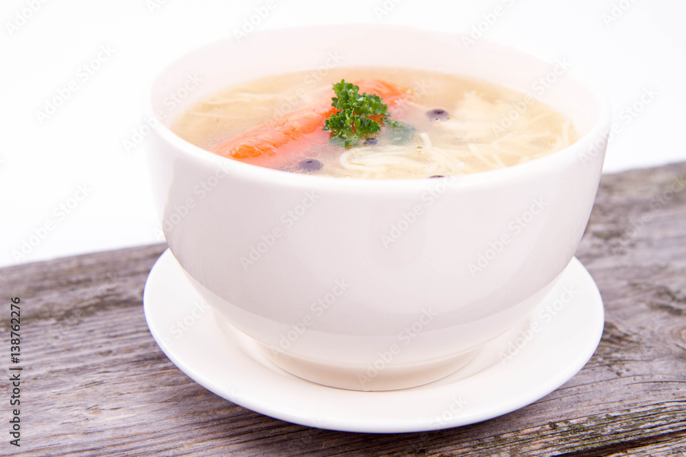 Chicken soup with carrots and parsley on wooden background Chicken soup with carrots and parsley on wooden background