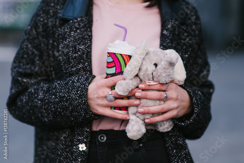 young stylish girl hands hold hot coffee and toys