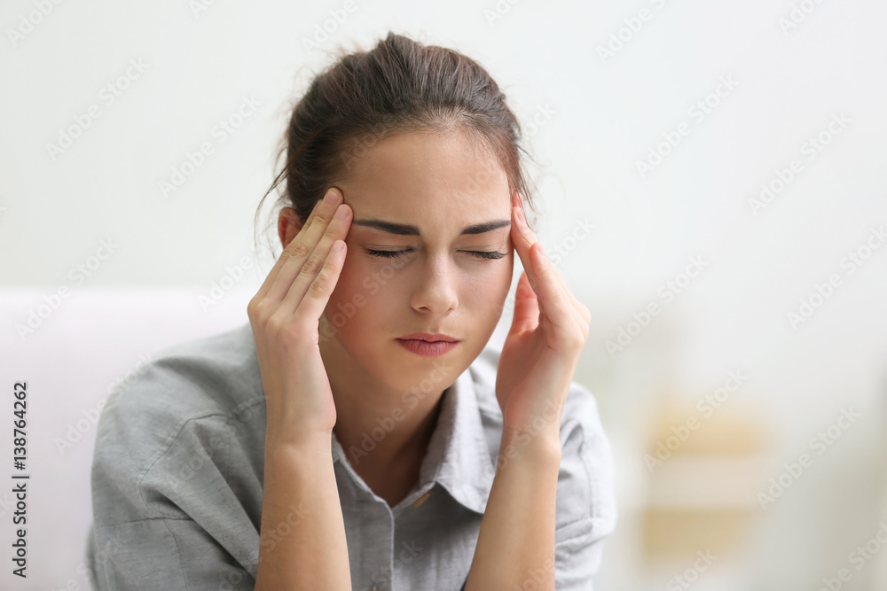 Portrait of young woman suffering from headache at home Portrait of young woman suffering from headache at home
