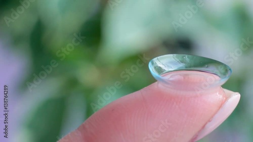 Macro filming a contact lens on a finger, HD footage photo