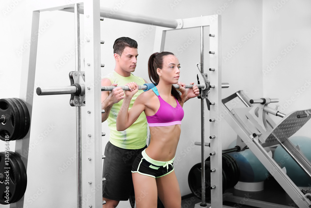 Beautiful sportive woman training with her trainer in gym Beautiful sportive woman training with her trainer in gym