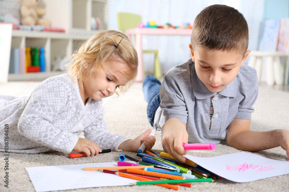 Two cute little children lying on floor and painting Two cute little children lying on floor and painting