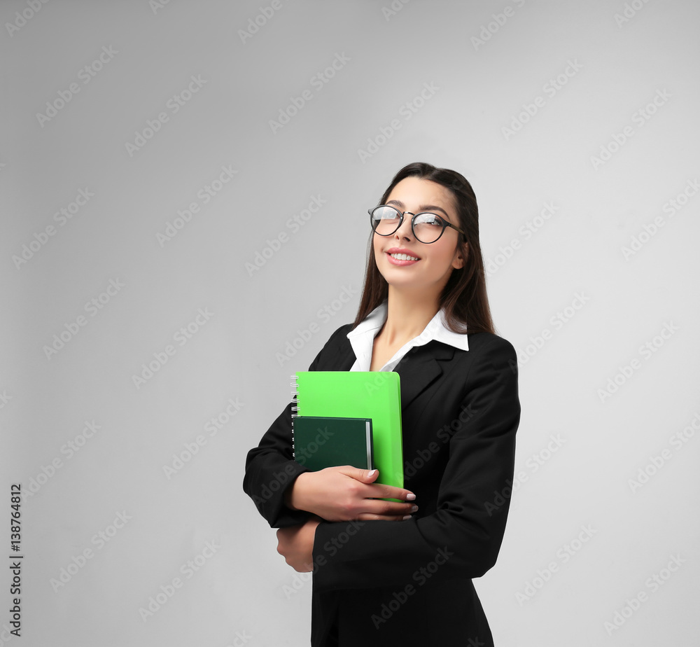 Beautiful young teacher on light background Beautiful young teacher on light background