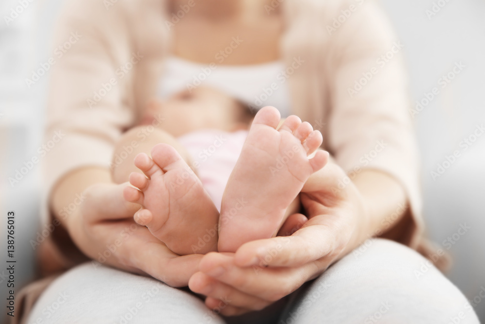 Mother holding cute baby on her knees, closeup Mother holding cute baby on her knees, closeup
