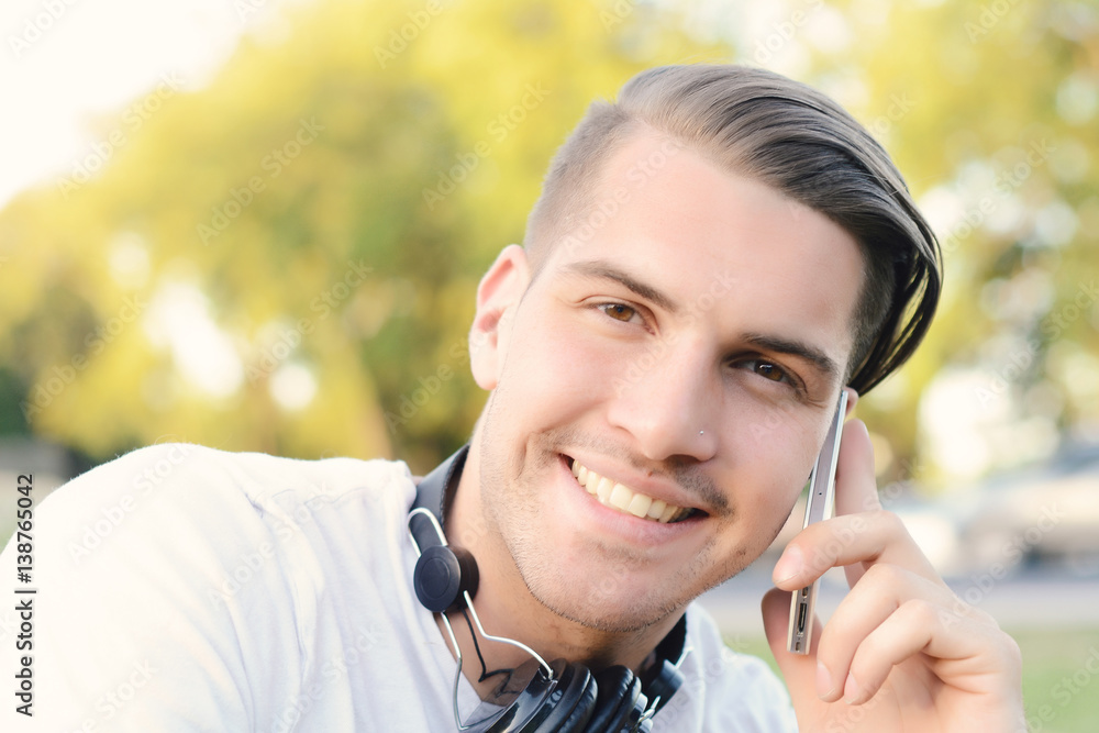 Young man talking on the phone. Outdoors. Young man talking on the phone. Outdoors.