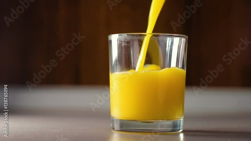 Pour the orange juice into a transparent glass, HD footage