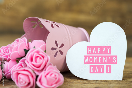 bouquet of flowers in rosy decorative bucket, note and space for text Happy Women's Day