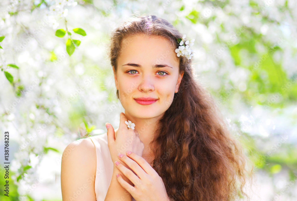 Portrait beautiful young woman with flowers over spring garden background Portrait beautiful young woman with flowers over spring garden background