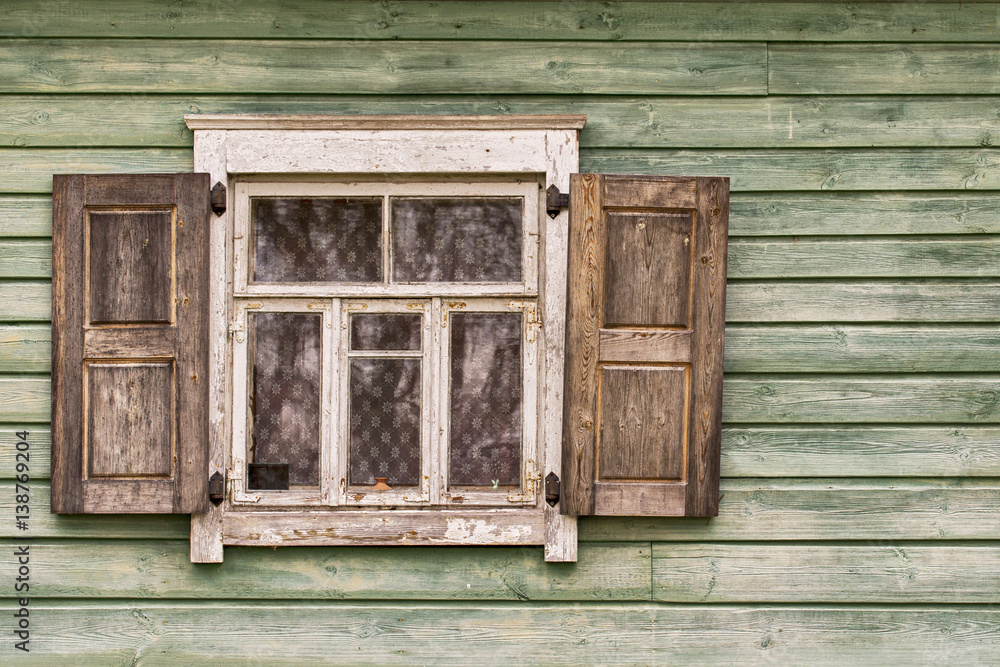 Old green wooden wall, window shutters opened Old green wooden wall, window shutters opened