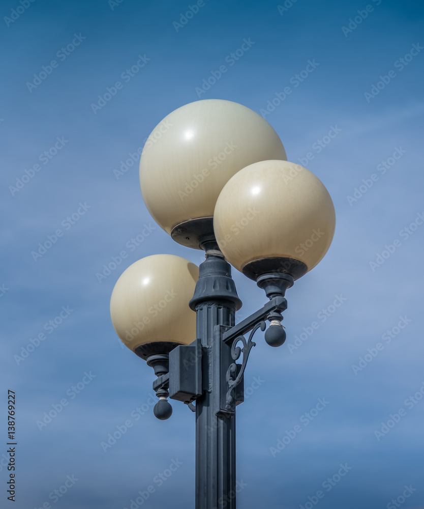 Closeup of a street round lantern on a beautiful blue sky background.