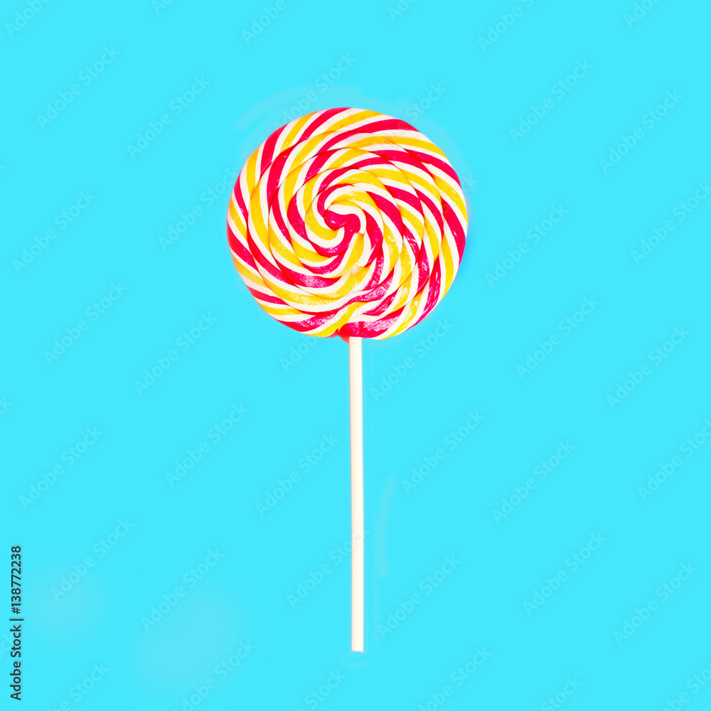 Colorful lollipop caramel on stick over blue background top view Colorful lollipop caramel on stick over blue background top view