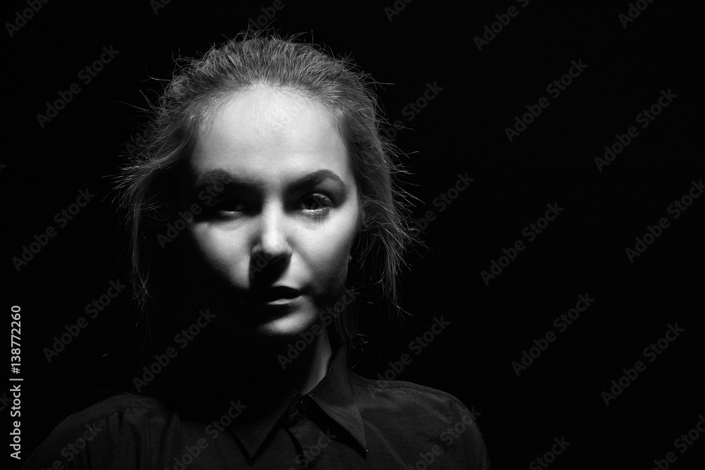 sad woman face on black background, monochrome