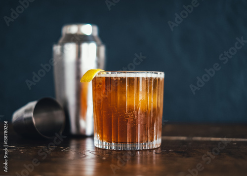 Mixing an afternoon drink, making an old fashion with a shaker and a peel