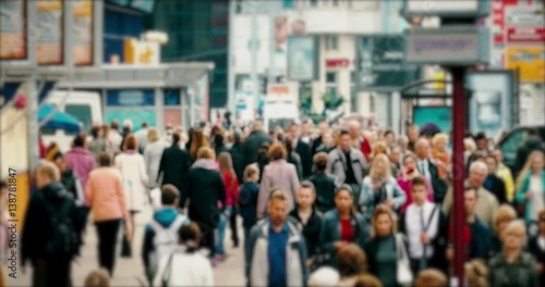 Crowd of People / Commuters Walking / Busy Street. Crowd on a busy street. People walk down a busy street with advertising, billboards, cars and public transport. Slow motion.