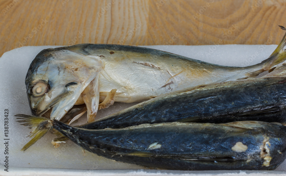 Steamed Mackerel on the white Styrofoam lay on the wooden floor. Steamed Mackerel on the white Styrofoam lay on the wooden floor.