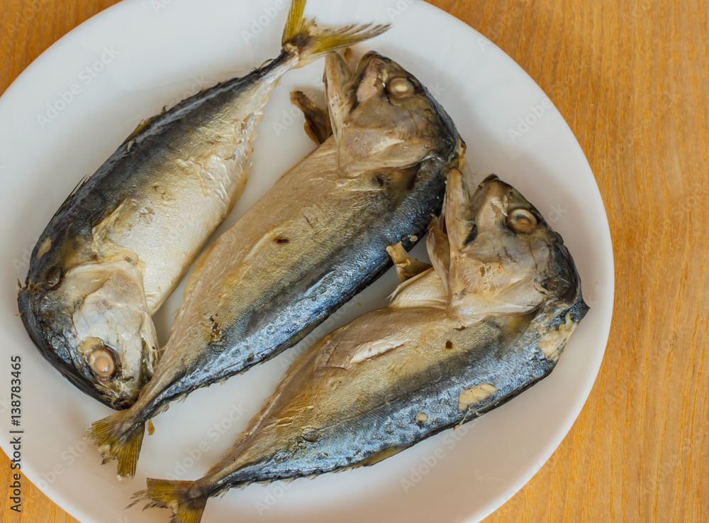 Mackerel, Steamed on plate white lay on the wooden floor.