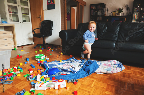 Obraz na plátně Adorable 1 year old baby boy with funny facial expression playing in a very mess