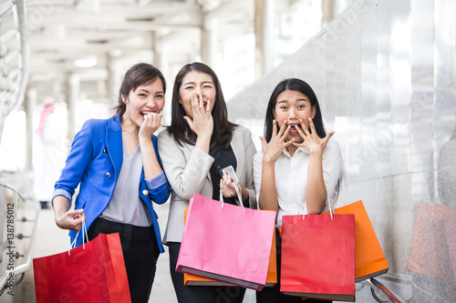 Happy shopping asia woman with a group of friends at the background.