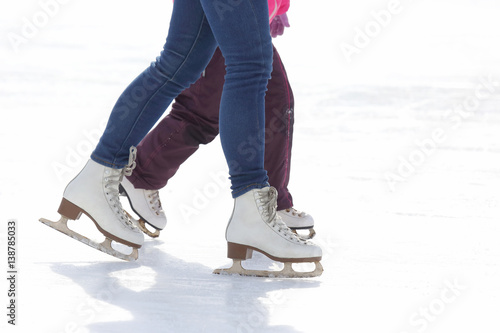 child and adult skates at the ice rink.