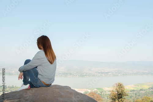 Young woman happy and relaxing in mountains with sunlight