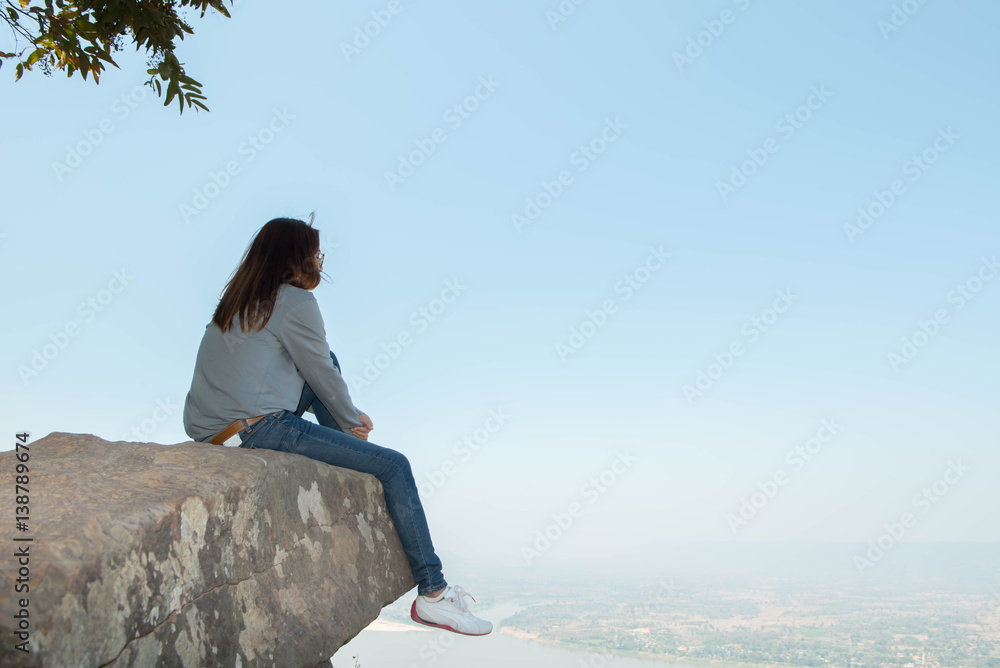 Young woman happy and relaxing in mountains with sunlight