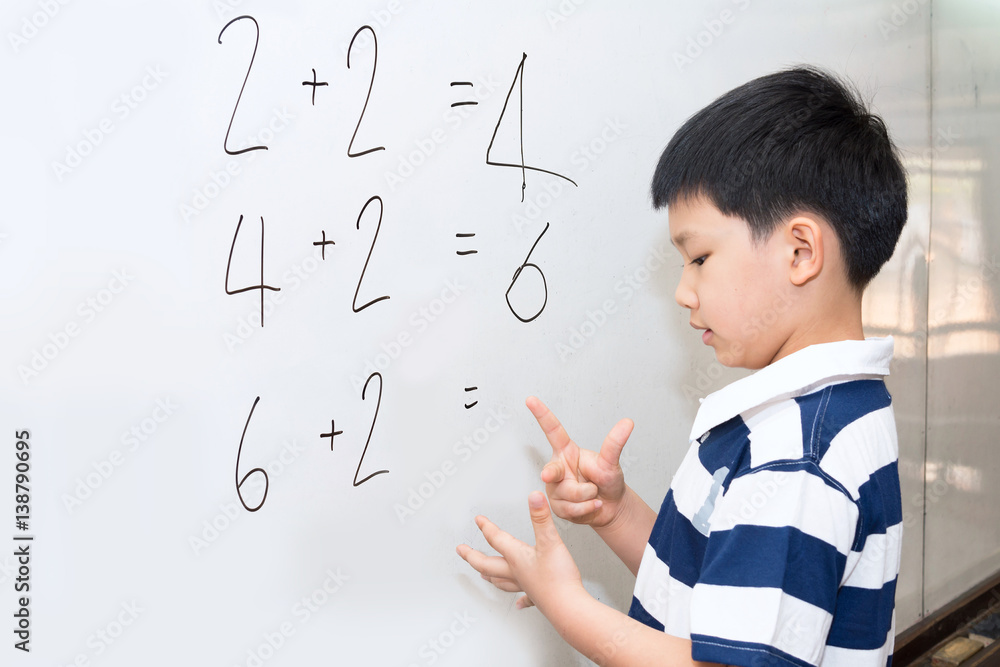 Asian boy learning calculation on white board in classroom. Stock Photo ...