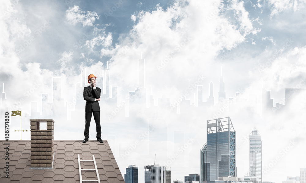 Engineer man standing on roof and looking away. Mixed media Engineer man standing on roof and looking away. Mixed media