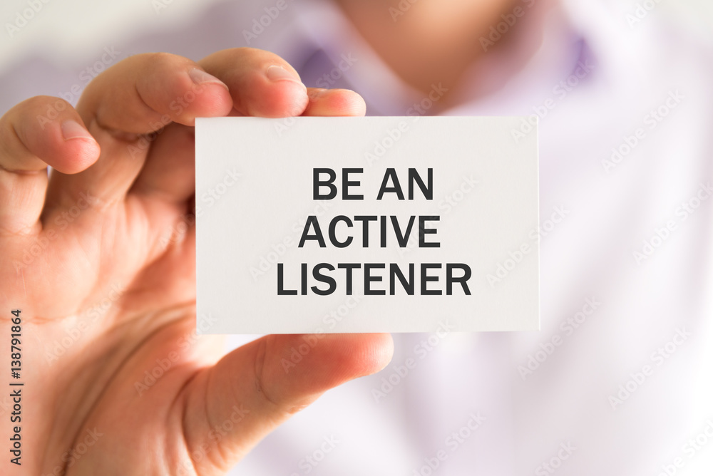 Businessman holding a card with BE AN ACTIVE LISTENER message Businessman holding a card with BE AN ACTIVE LISTENER message