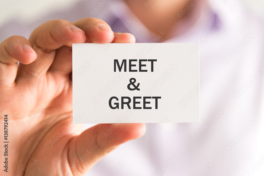 Businessman holding a card with MEET AND GREET message