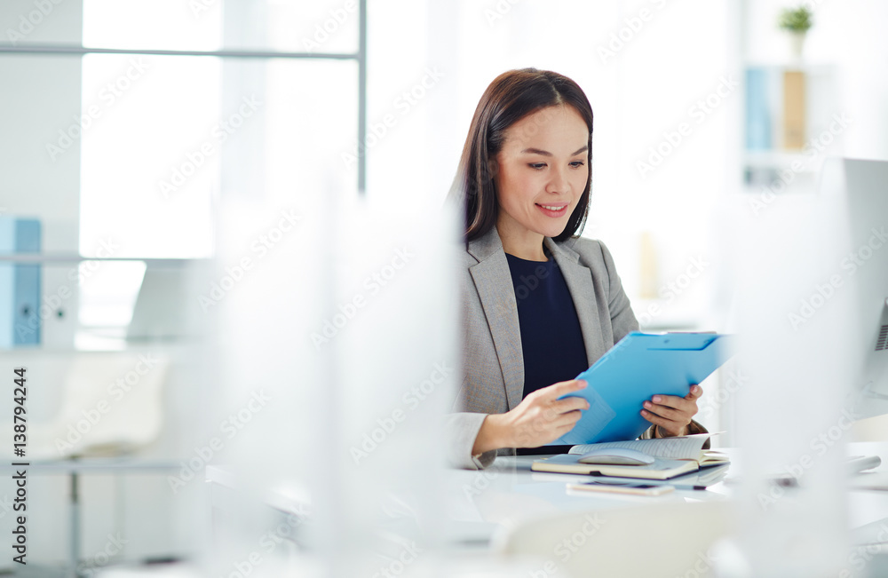 Portrait of successful Asian businesswoman busy working at desk in modern office, sorting folders with paperwork and documentation Portrait of successful Asian businesswoman busy working at desk in modern office, sorting folders with paperwork and documentation