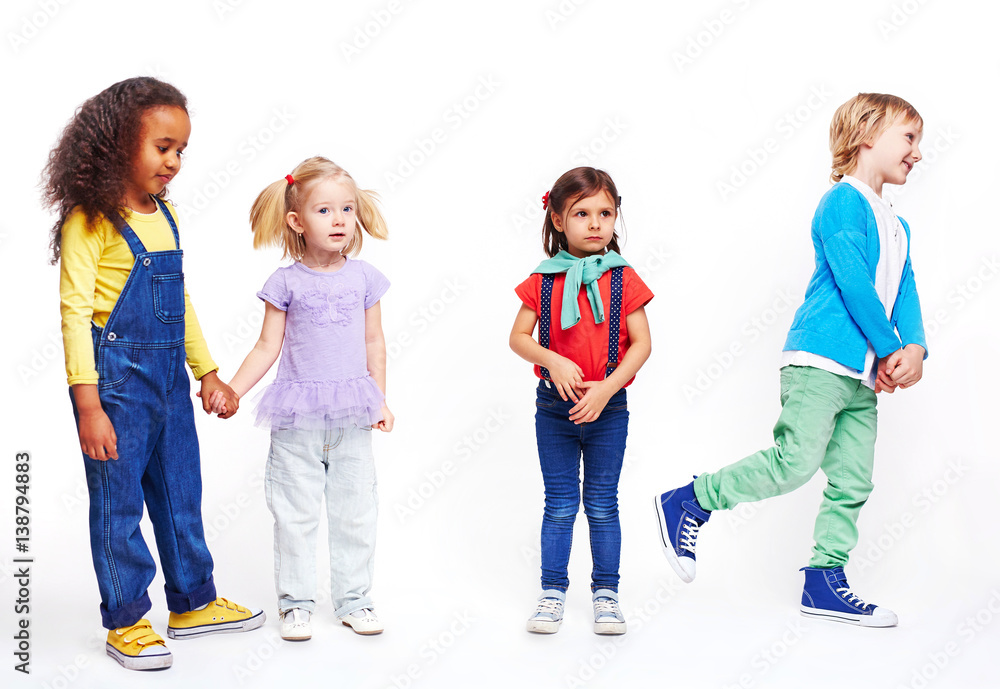 Studio portrait of children against white background: cutout of four kids in bright clothes, two girls holding hands, boy running and confused little girl Studio portrait of children against white background: cutout of four kids in bright clothes, two girls holding hands, boy running and confused little girl