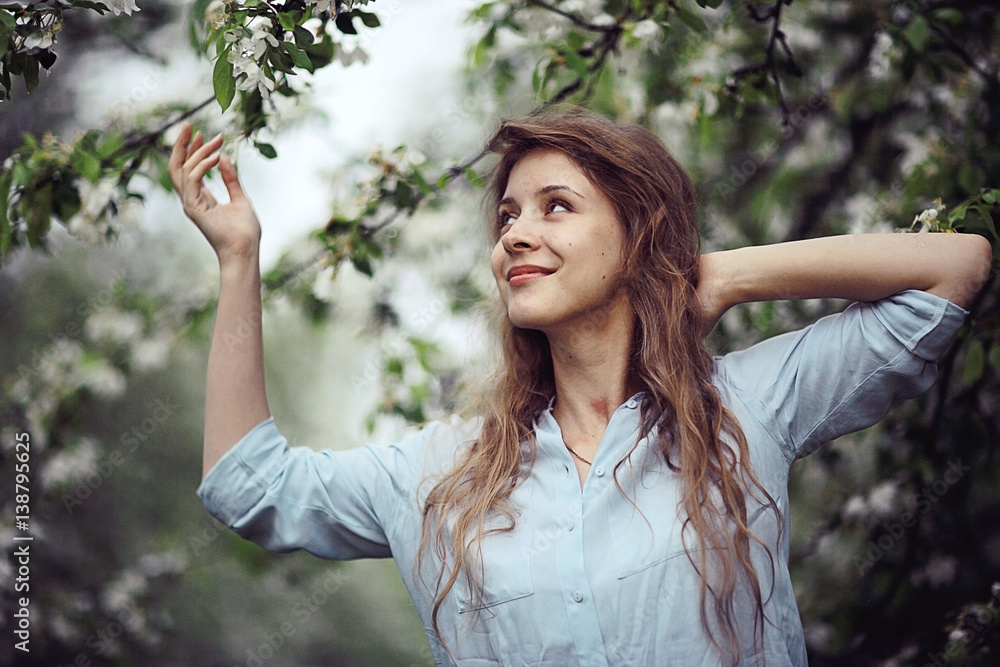young happy woman walking in an apple orchard in the spring flowers white young happy woman walking in an apple orchard in the spring flowers white
