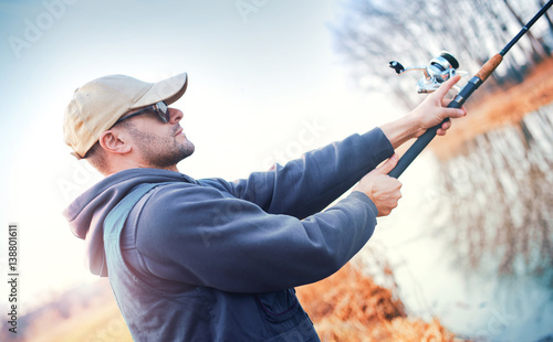 Young angler enjoys in fishing on the river. Sport, recreation, lifestyle photo