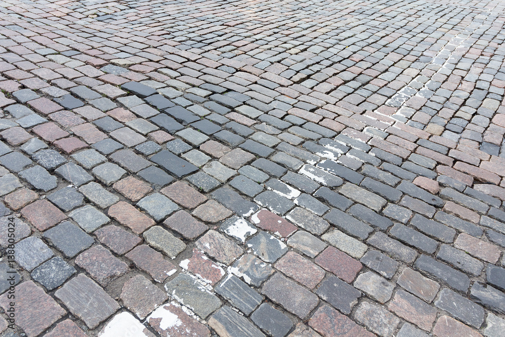 Fototapeta premium Old paving stones and remnants of road markings. Backgrounds and textures