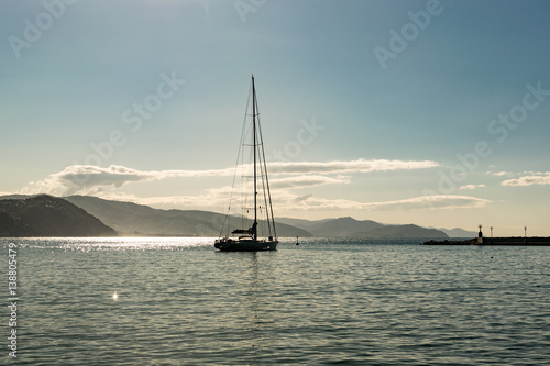 Sailing boat on a calm sea of Liguria coast, Italy. Serene scene landscape.