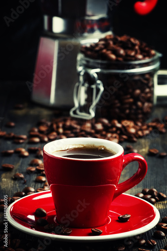 Black coffee in a red cup, black background, selective focus