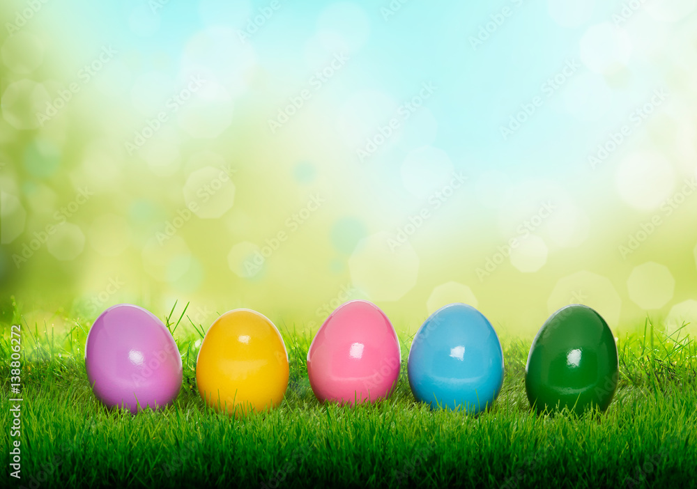 Colourful painted Easter Eggs on green grass and blurred garden background