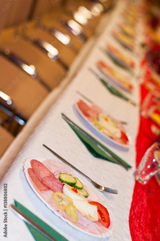 Decorated catering banquet table with appetizers with ham, salami and eggs. Selective focus. Vertical photo Decorated catering banquet table with appetizers with ham, salami and eggs. Selective focus. Vertical photo