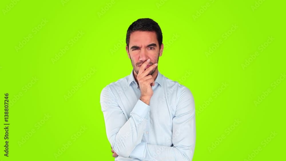 Suspicious young man against green background Suspicious young man against green background